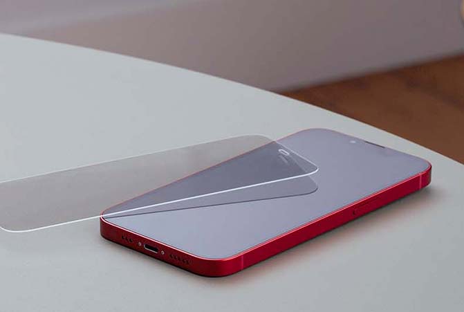 The armoured glass is next to the mobile phone.