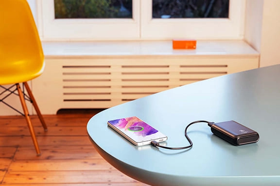 Power bank charges a mobile phone on a table