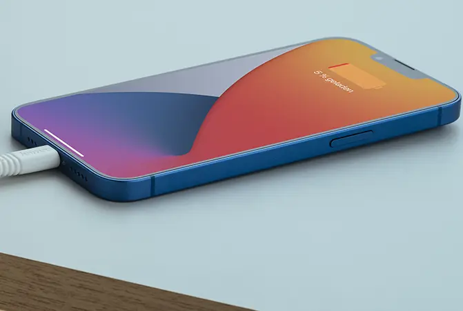 An iPhone charges slowly and lies on the table.