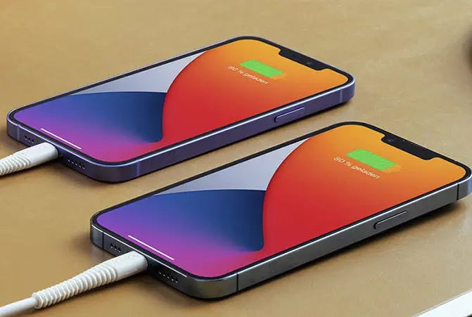 Two iPhones are lying on the table and are being charged.