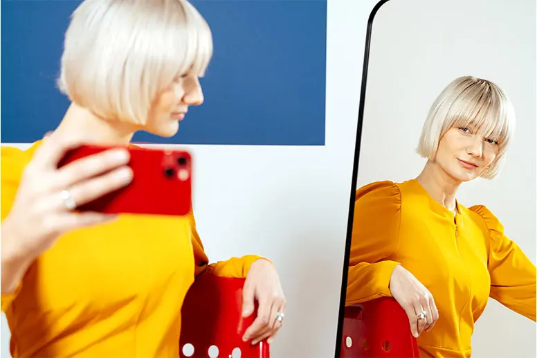 Selfie over the shoulder, looking into a small mirror.