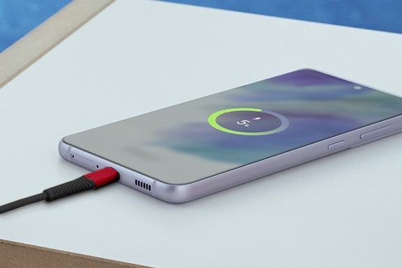 Android smartphone lies on a table and are charged with charging cable "Extreme".