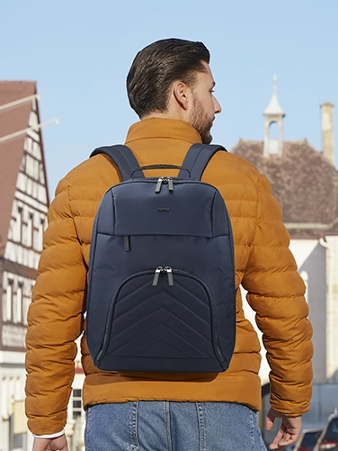 A young man is out and about in the city with the Hama "Premium Lightweight" laptop rucksack on his back