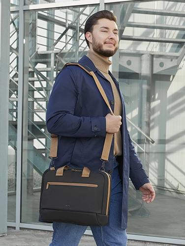 Businessman carries the Hama "Ultra Lightweight" laptop bag over his shoulder on the way to the next meeting