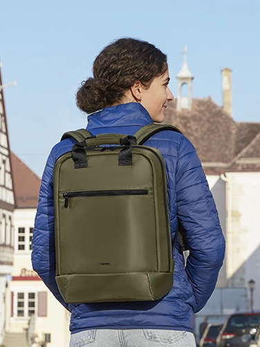 A young woman walks through the city with the Hama "Ultra Lightweight" laptop rucksack on her back