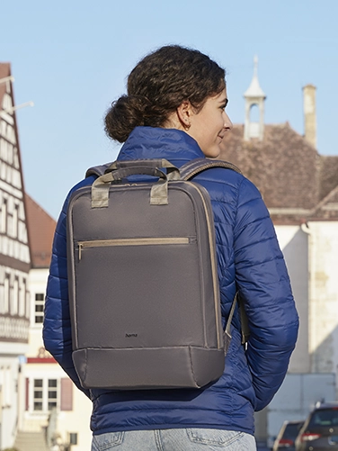 A young woman walks through the city with the Hama "Ultra Lightweight" laptop rucksack on her back