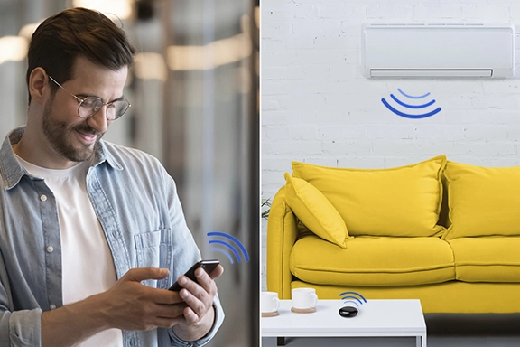 You can see a man using a smartphone to operate the Hama smart WLAN universal remote control and thus the air conditioning system in the living room.