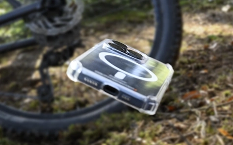 Smartphone in mobile phone case falls off bicycle onto forest floor.